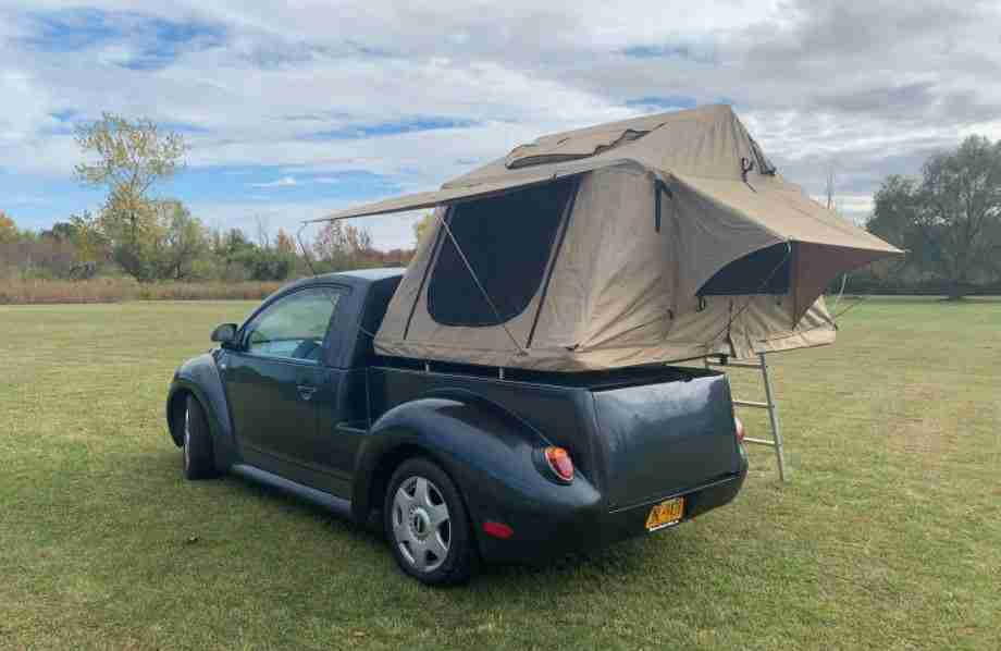 VW Beetle pick-up camper con tienda montada